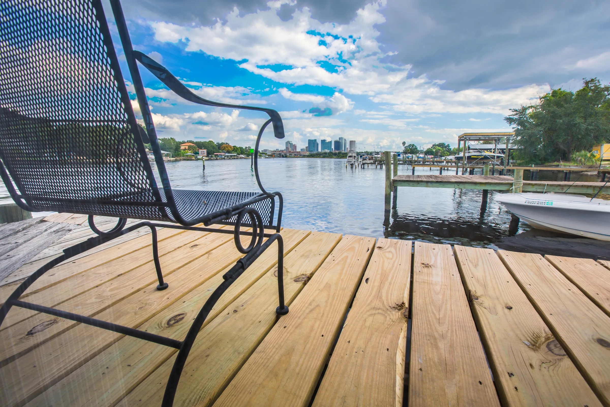 Iron chair on new wood dock with wide bay and city view
