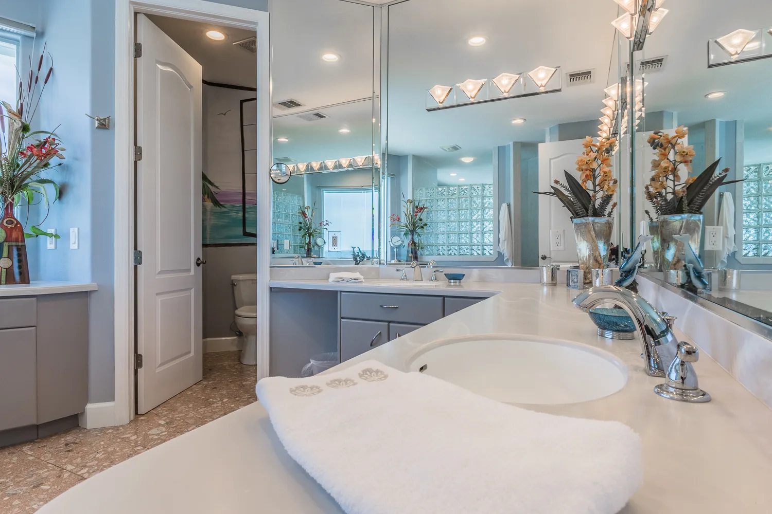 Bathroom vanity with double mirrors, orchid arrangements and folded towels