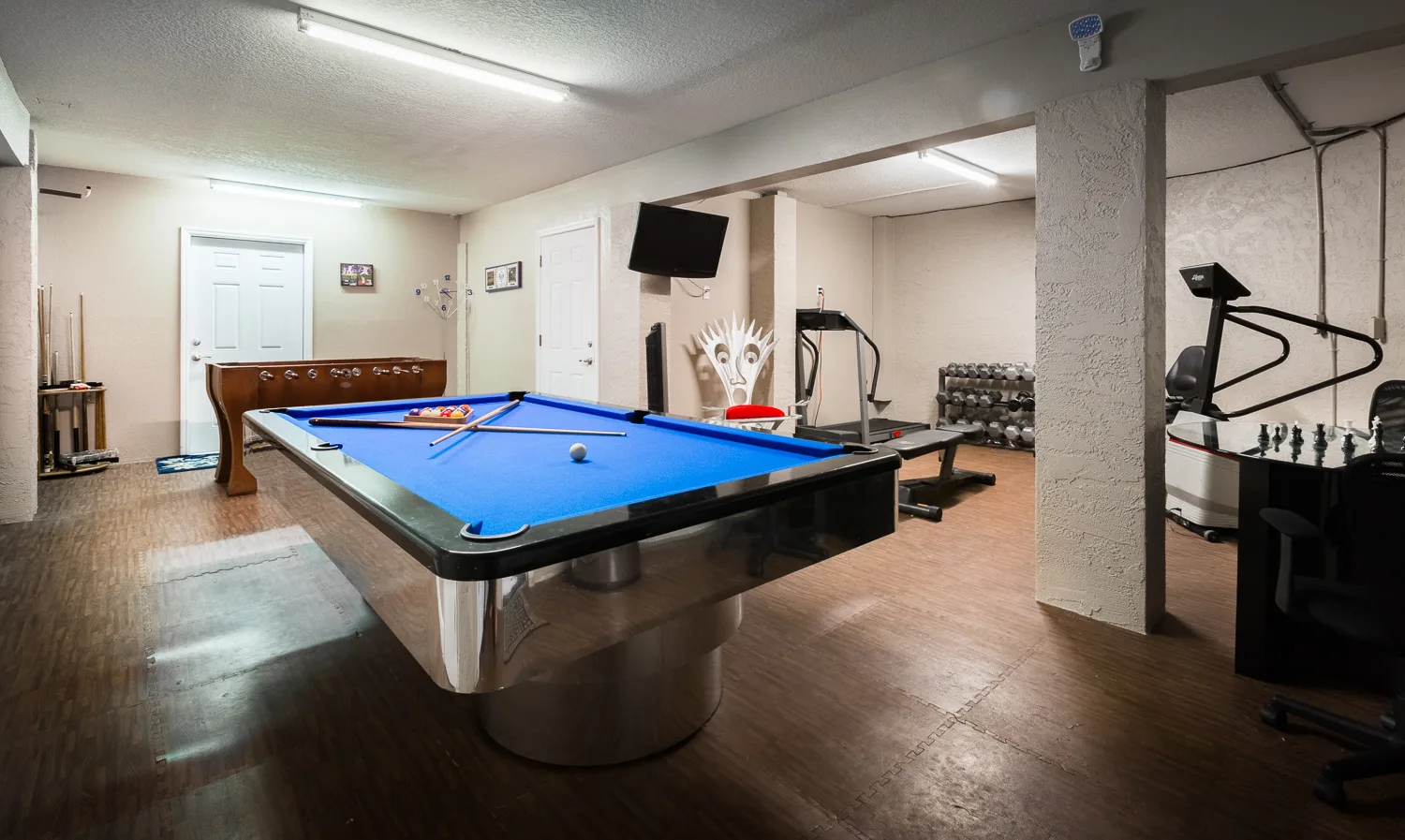 Game room with pool table, treadmill, weights and exercise bikes