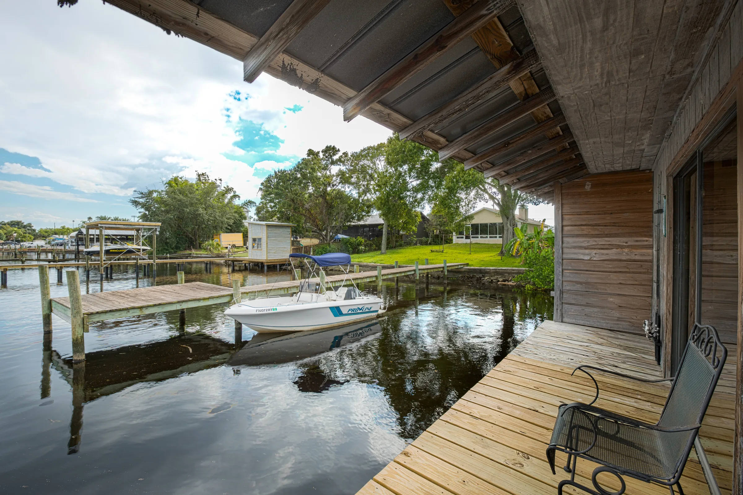 Boathouse deck overlooking canal with motorboat tied to private dock