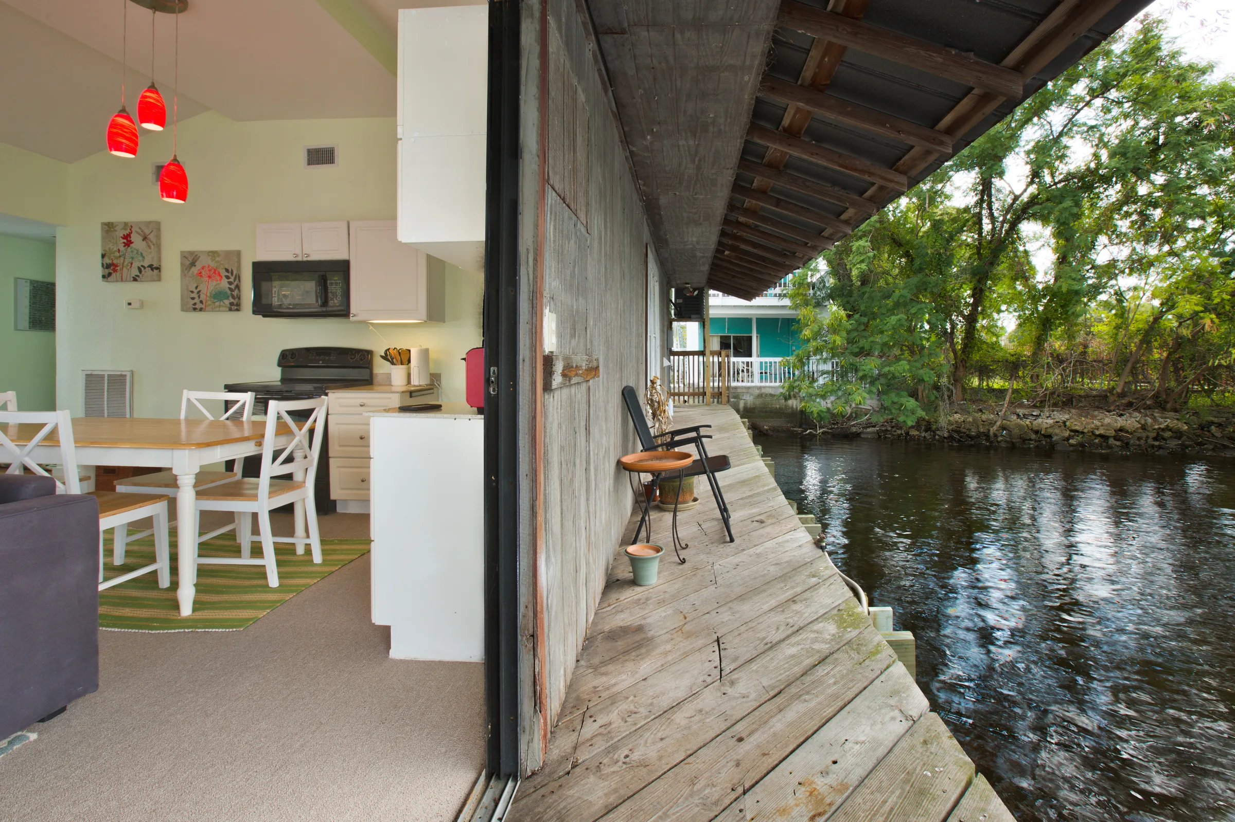 Open kitchen and dining area flowing onto a waterfront boathouse deck