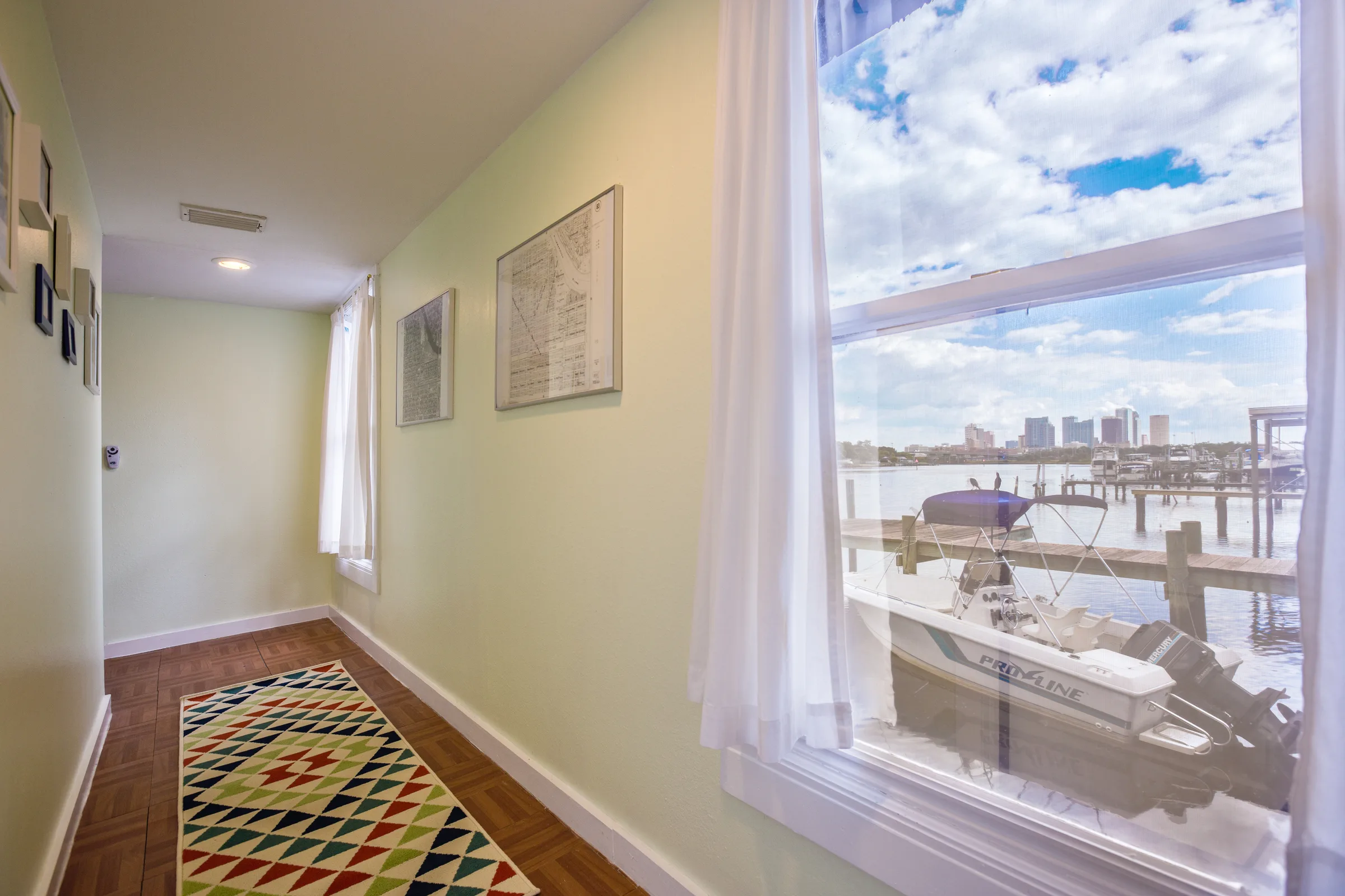 Bright hallway with colorful geometric runner and window overlooking docked boats