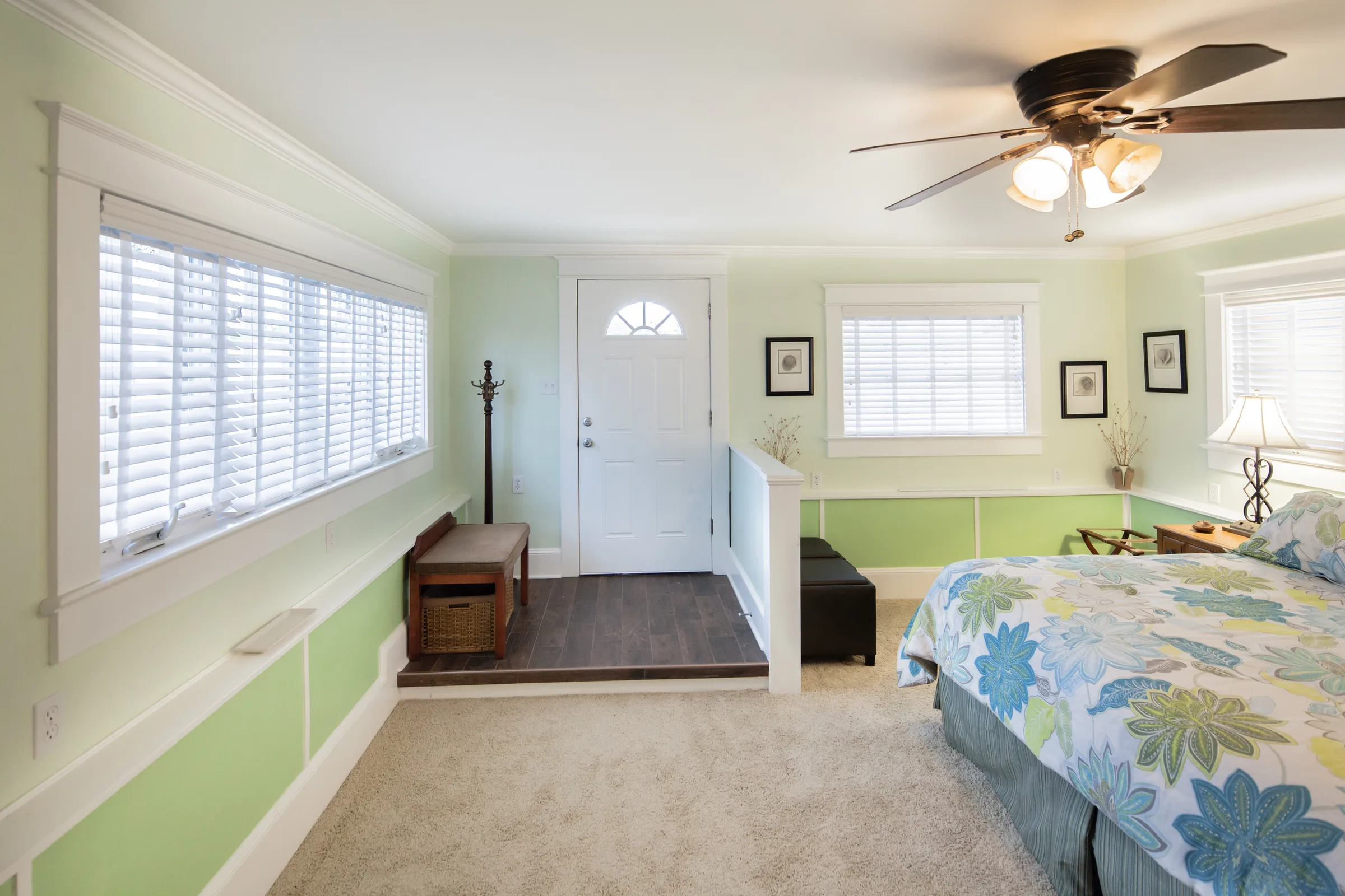 Bright green and white bedroom with floral bedding and entry landing