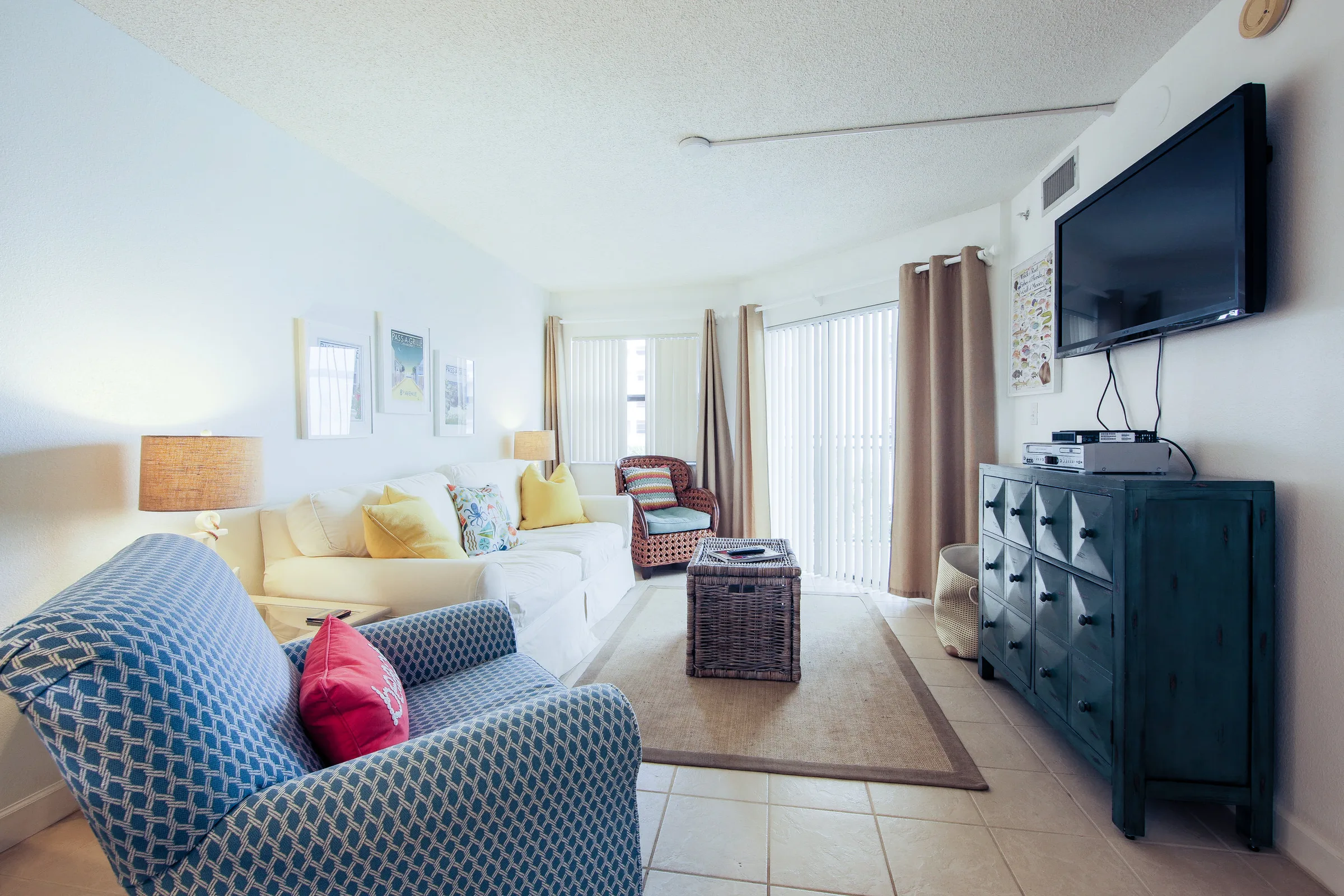 Cheerful condo living room with patterned blue armchair and flat-screen TV