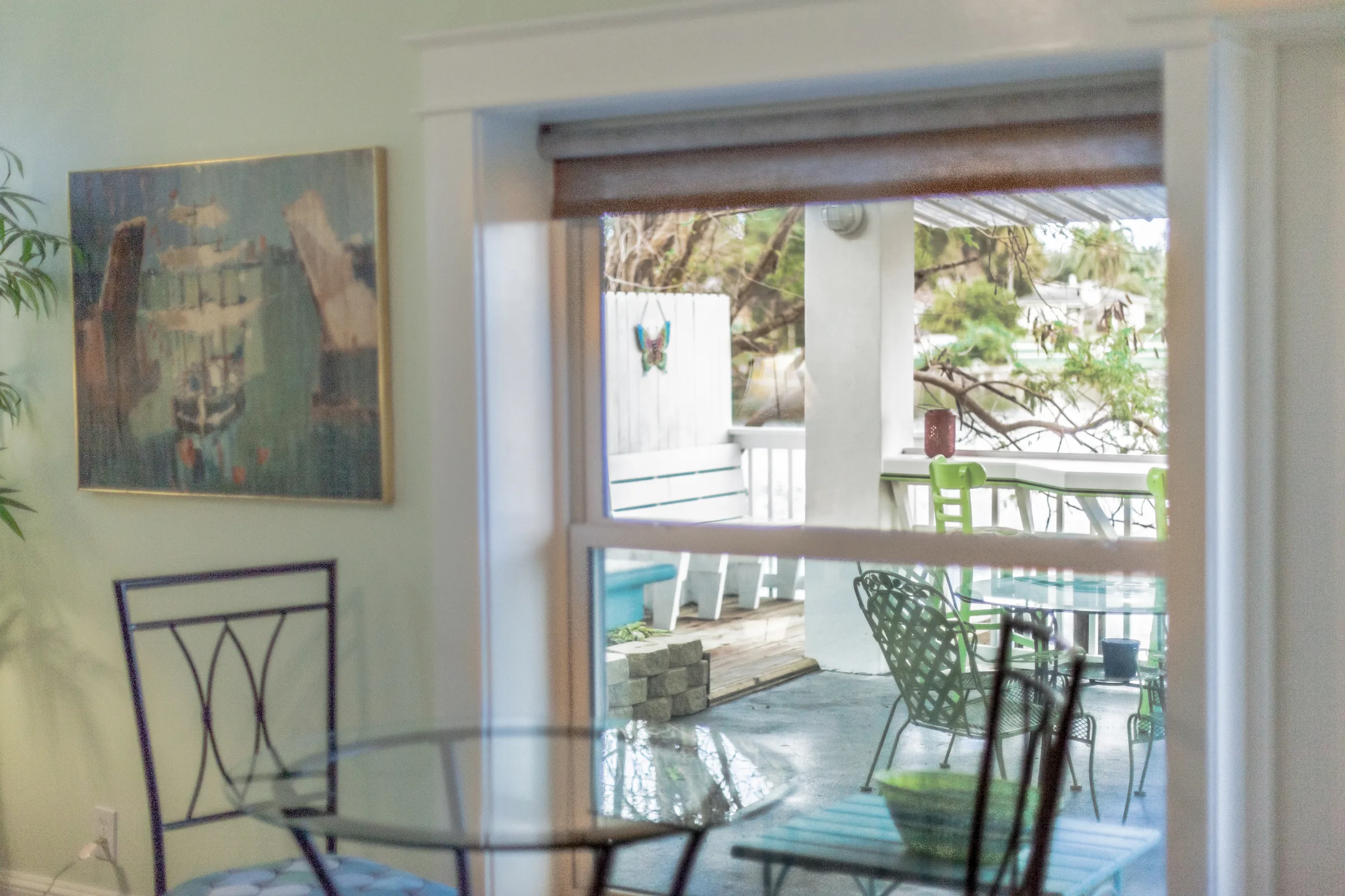Glass dining table by a window overlooking a covered porch outside