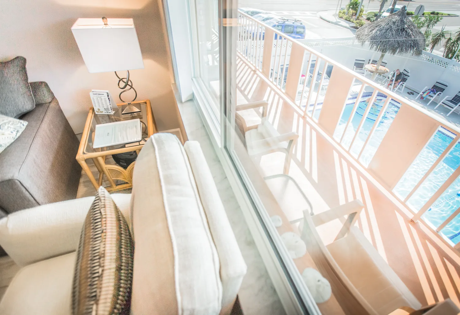 Living room slider opening to a balcony overlooking the pool below